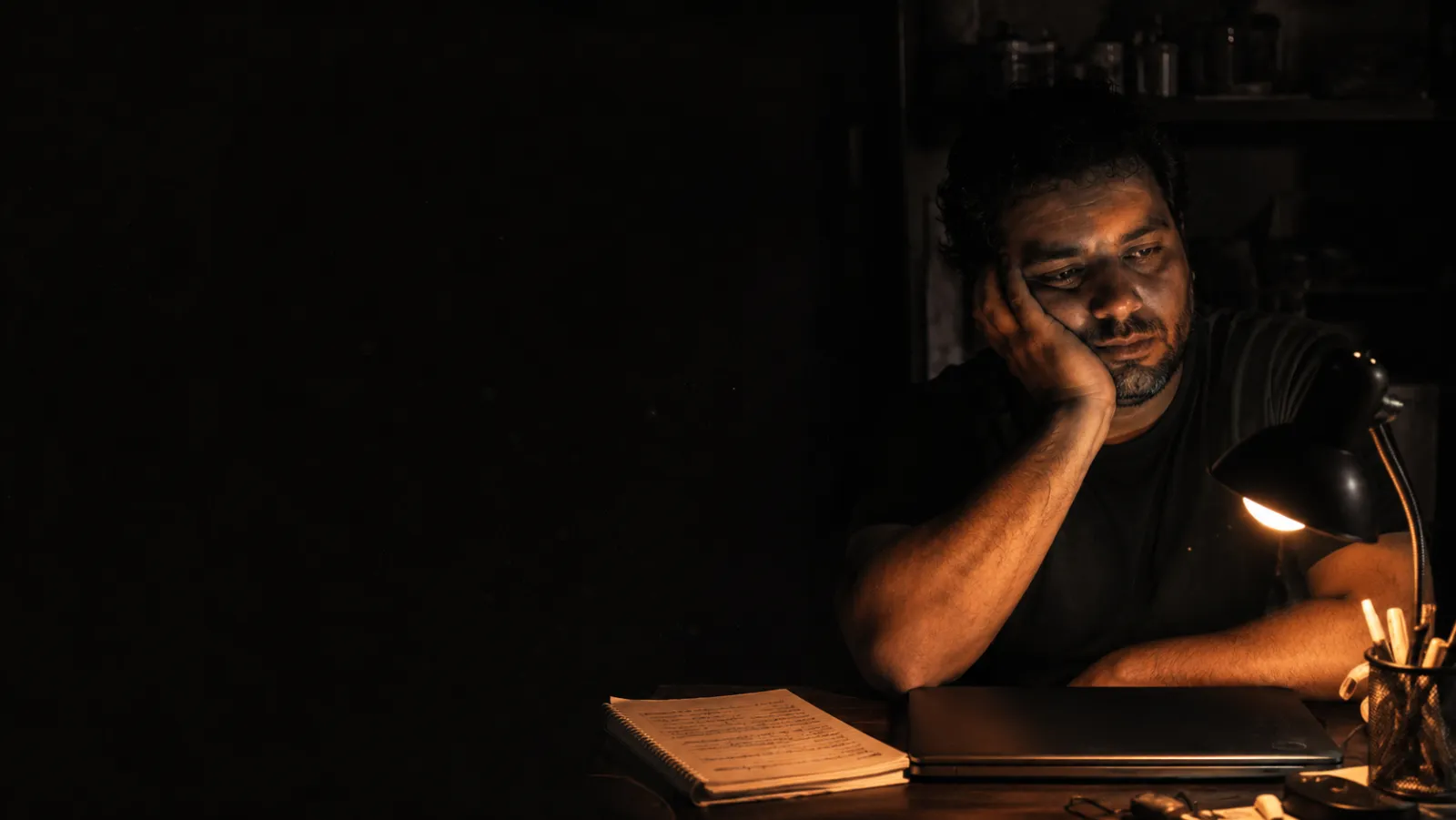 Homem parado à noite diante da tarefa, no escuro